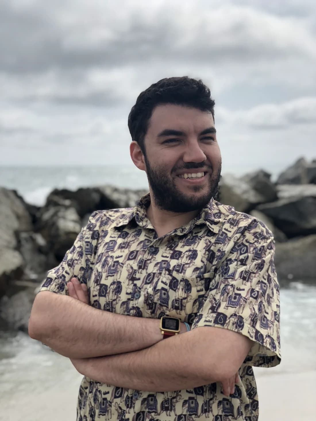 Darrel smiling beside the ocean